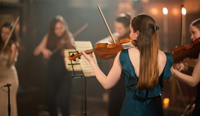 The Piccadilly Sinfonietta performing in a candlelit church