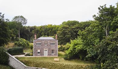 an image showing a cottage surrounded by woodland