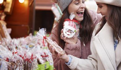two women with gingerbread at a Christmas market