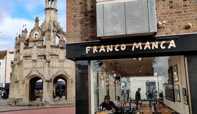 A view of FrancoManca restaurant in Chichester with the market cross behind