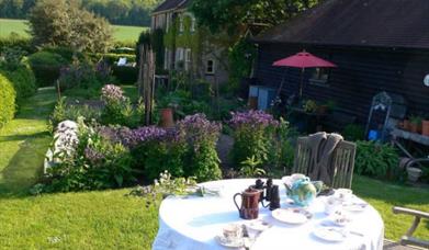 a tea table in a garden overlooking countryside