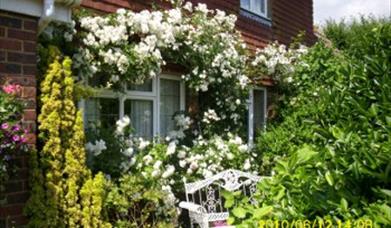 a cottage surrounded by flowers