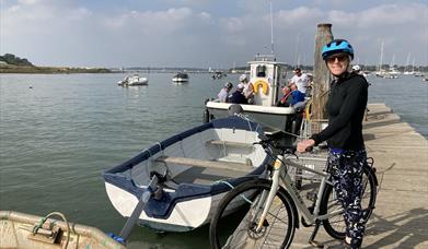 A person with bike near a ferry at Chichester Harbour
