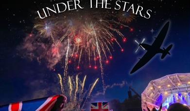 The Proms concert. Flags are flying as fireworks go off in the night sky.